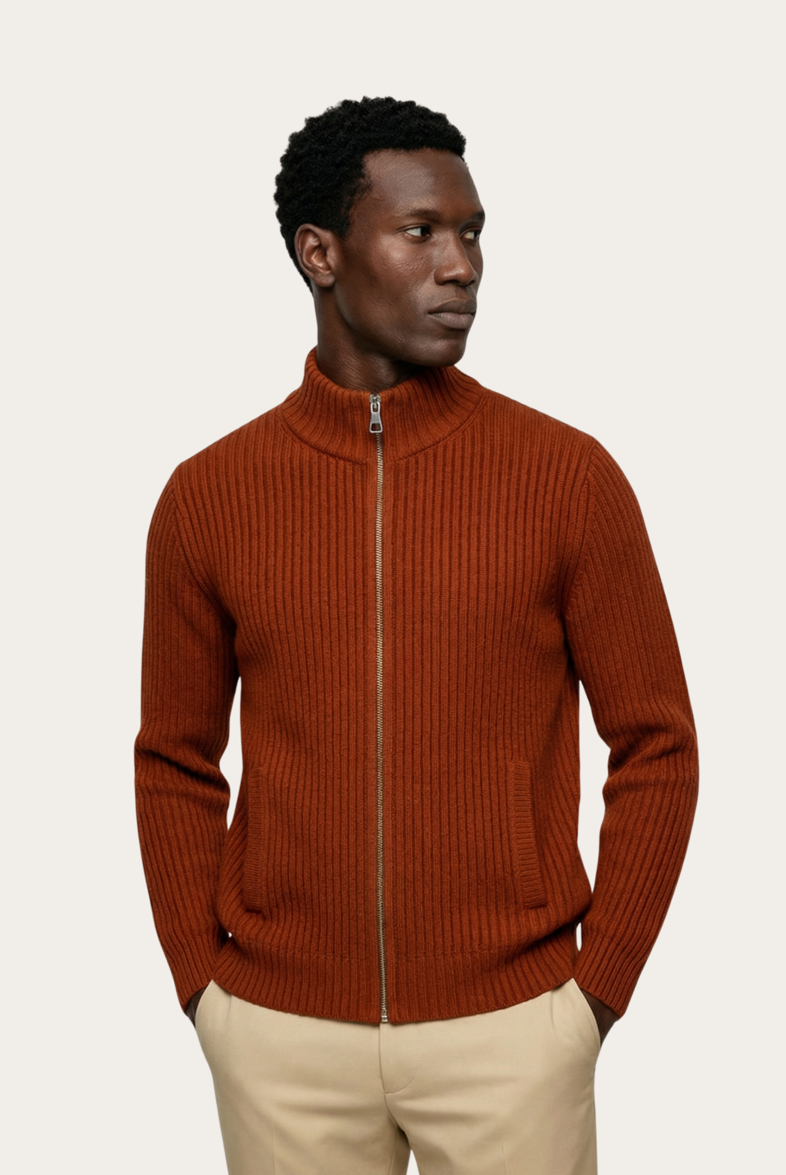 Man wearing a brown ribbed knit sweater with a zipper on a beige background