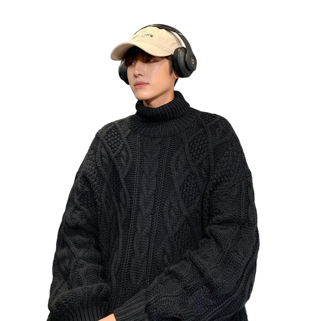 Person wearing a black cable knit sweater, beige visor, and headphones on a white background
