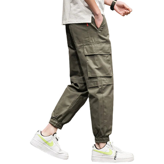 Person wearing olive green cargo pants with a white background