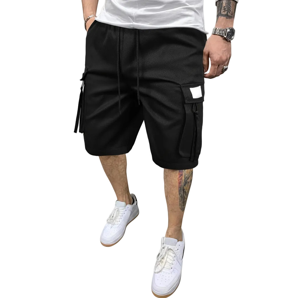 Person wearing black cargo shorts on a white background
