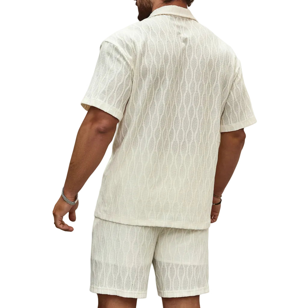 Man wearing a beige patterned shirt and shorts set on a white background